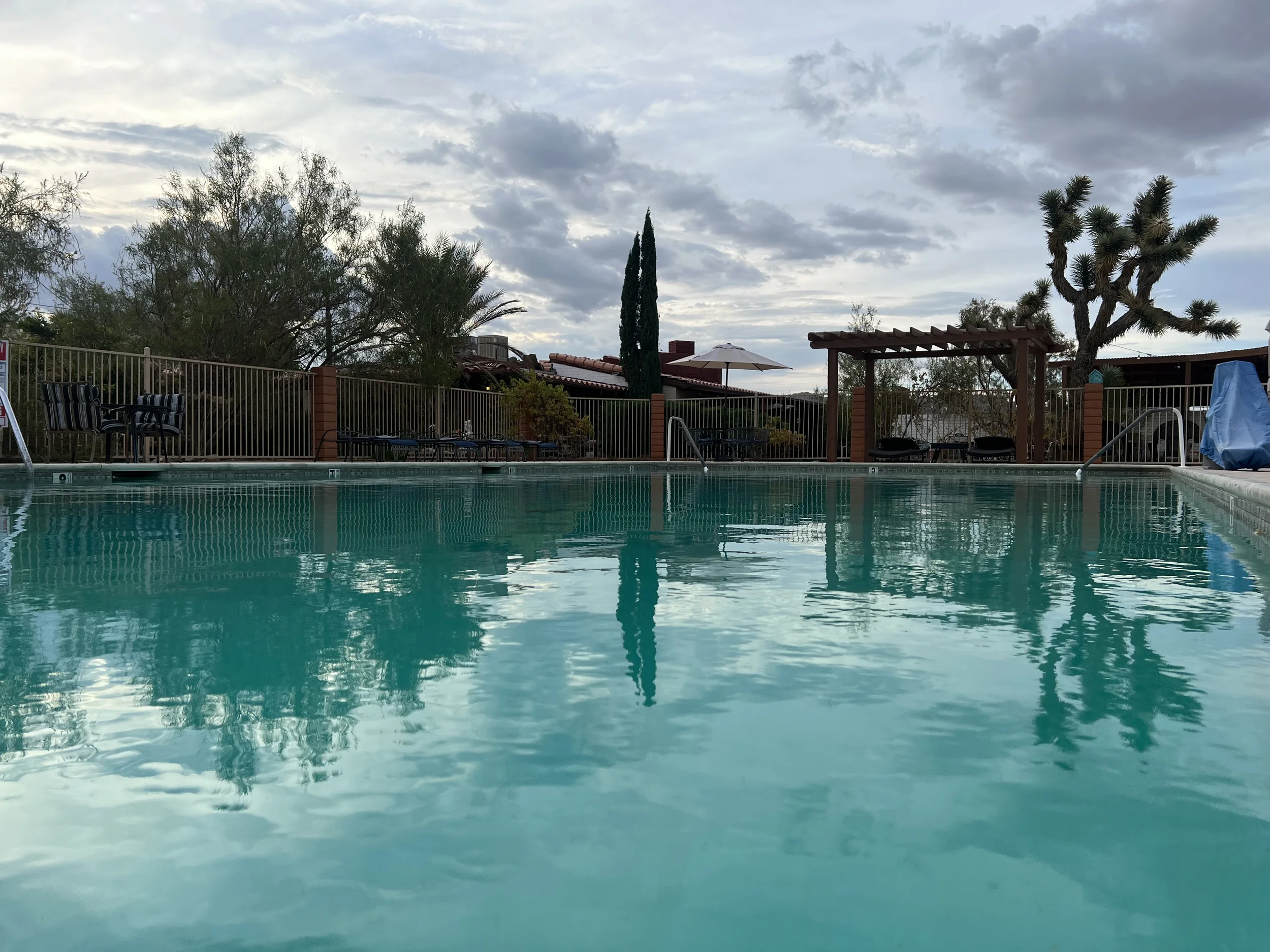 A veiw of lounging chairs across a pool. 